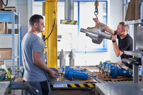 Mechanic lifting a gearbox with a small crane